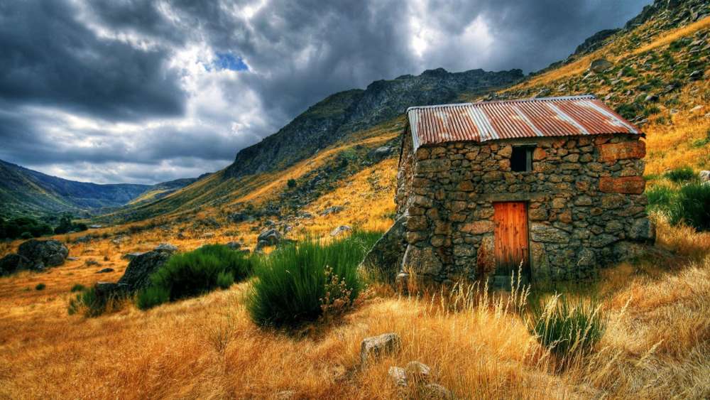 Rustic Cottage Amidst Rolling Hillscapes wallpaper