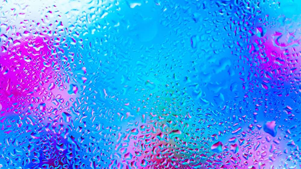Glistening Droplets on Vibrant Glass Surface wallpaper