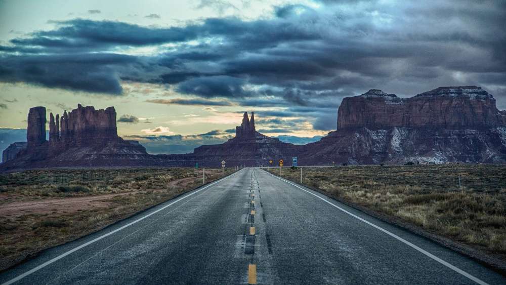 Vast Desert Roadway Under Dramatic Skies wallpaper