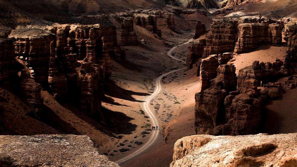Winding Desert Road Through Rugged Terrain wallpaper