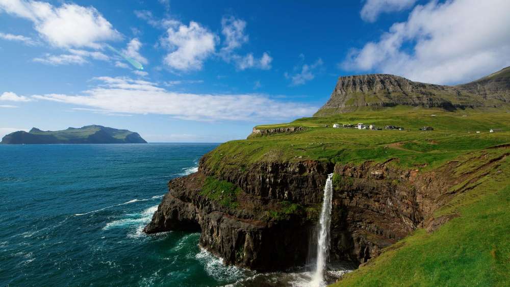 Majestic Waterfall Cascading into the Sea wallpaper