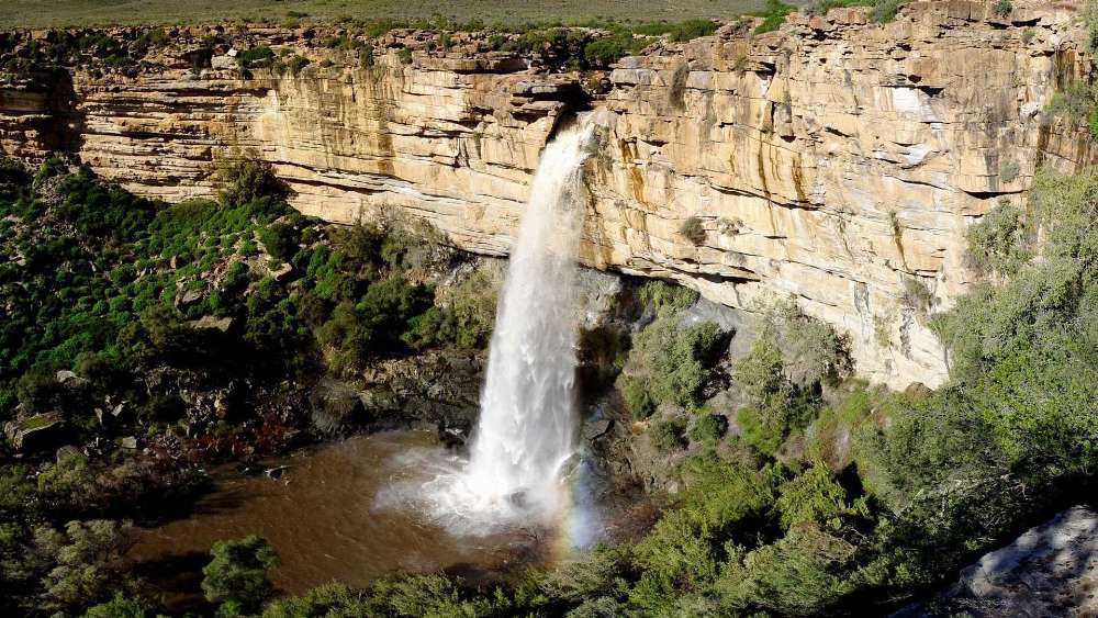 Majestic Waterfall Surrounded by Nature's Beauty wallpaper