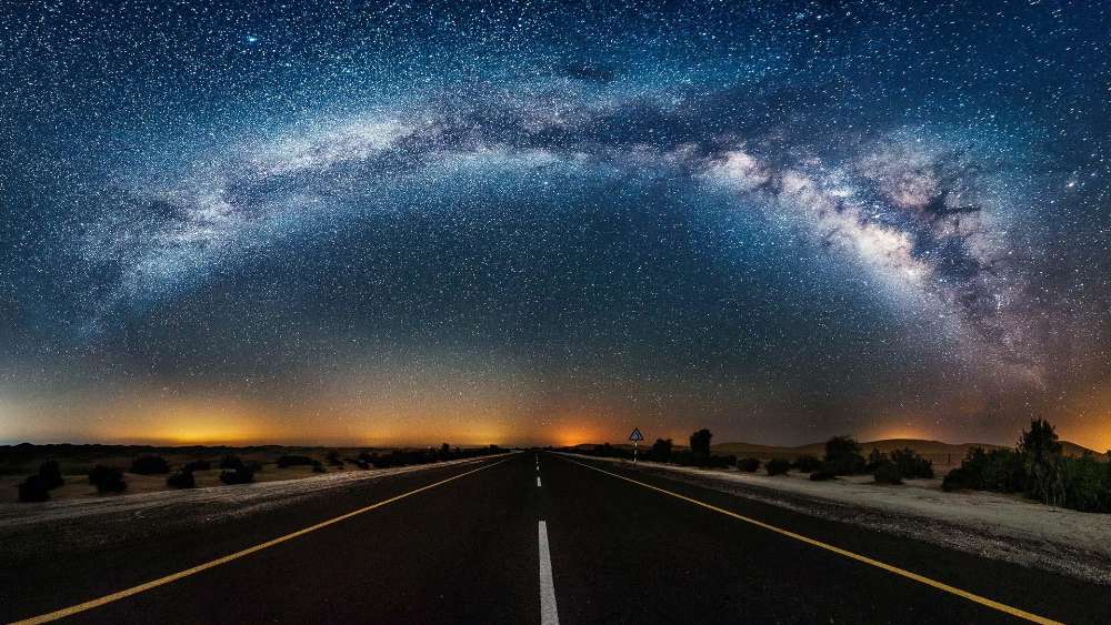 Starry Desert Road Under Cosmic Splendor wallpaper