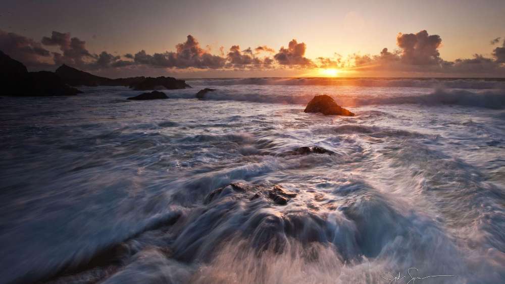 Serene Waves at Sunset Over Rocky Shoreline wallpaper