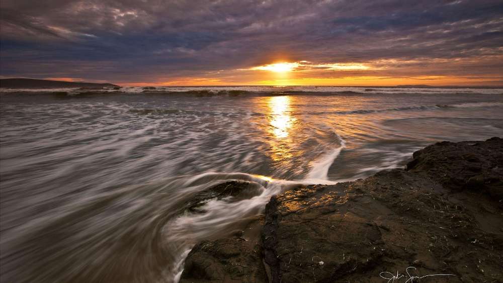 Serene Sunset Over Ocean Waves wallpaper