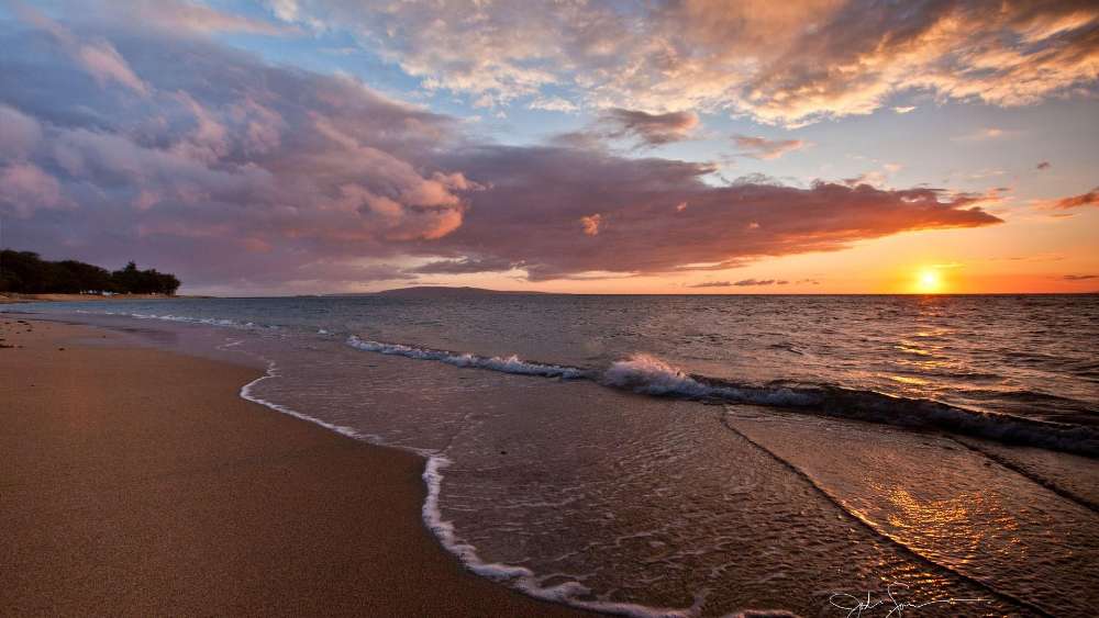 Serene Sunset Over Tranquil Beach Waves wallpaper
