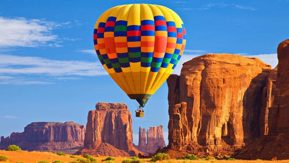 Colorful Balloon Adventure Over Monument Valley wallpaper