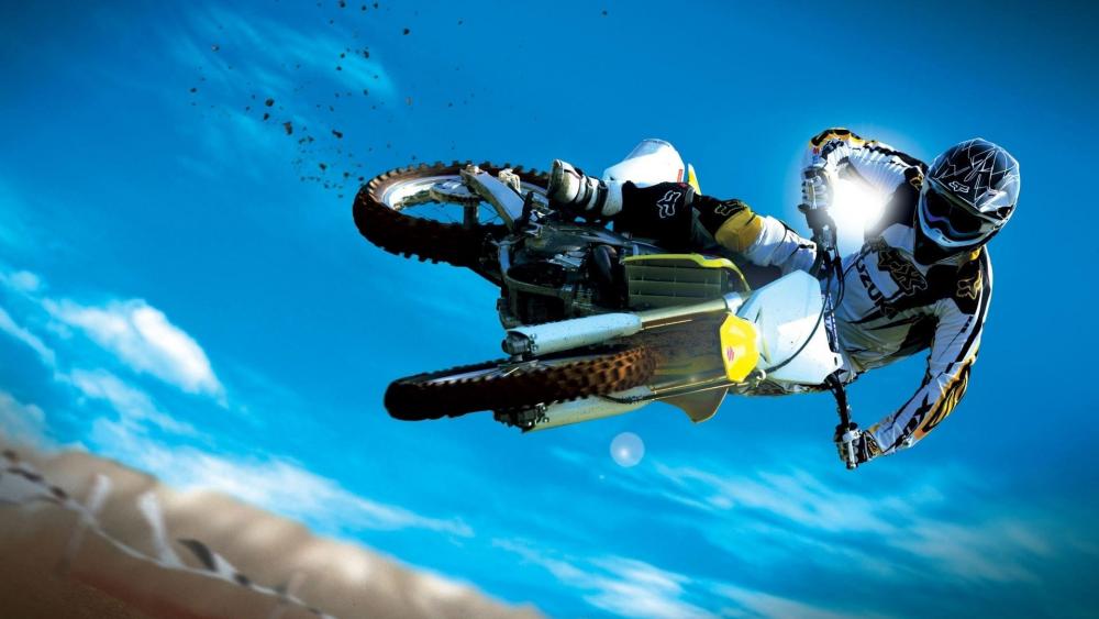 Motocross Rider Soaring High on Track wallpaper
