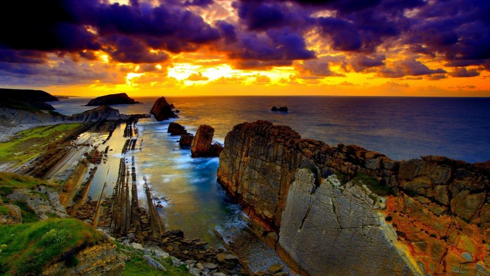 Sunset above the rocky coast wallpaper