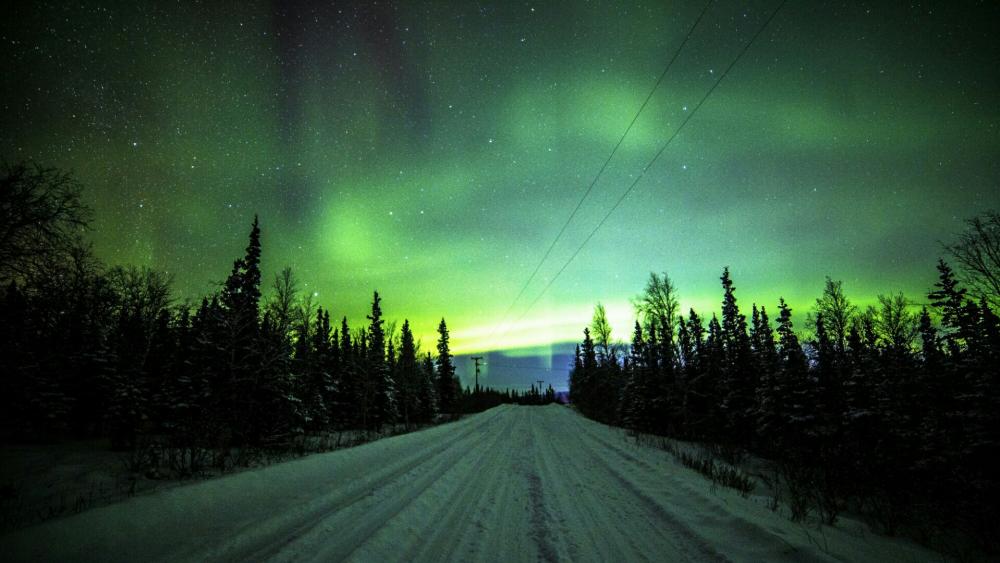 Northern lights over the snowy road wallpaper