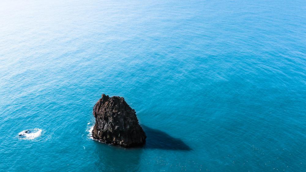 Small rock islet in the blue sea wallpaper