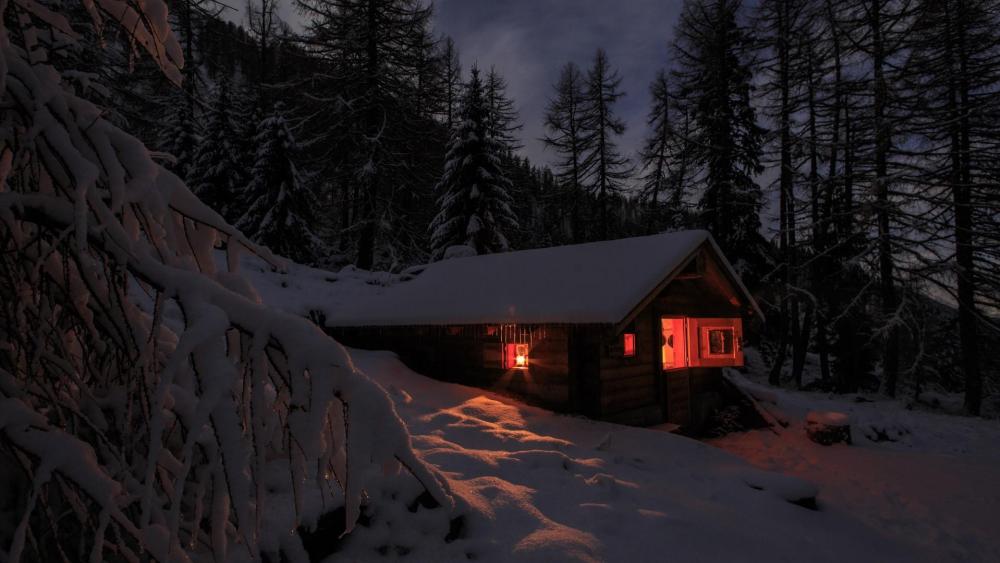 Snowy cabin in the winter forest at night wallpaper