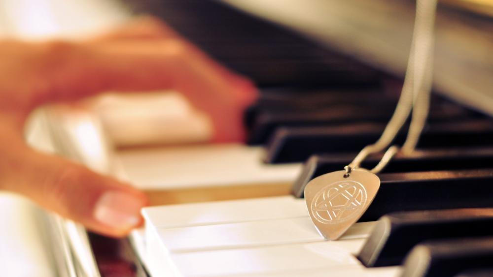 Necklace with pendant on the piano wallpaper