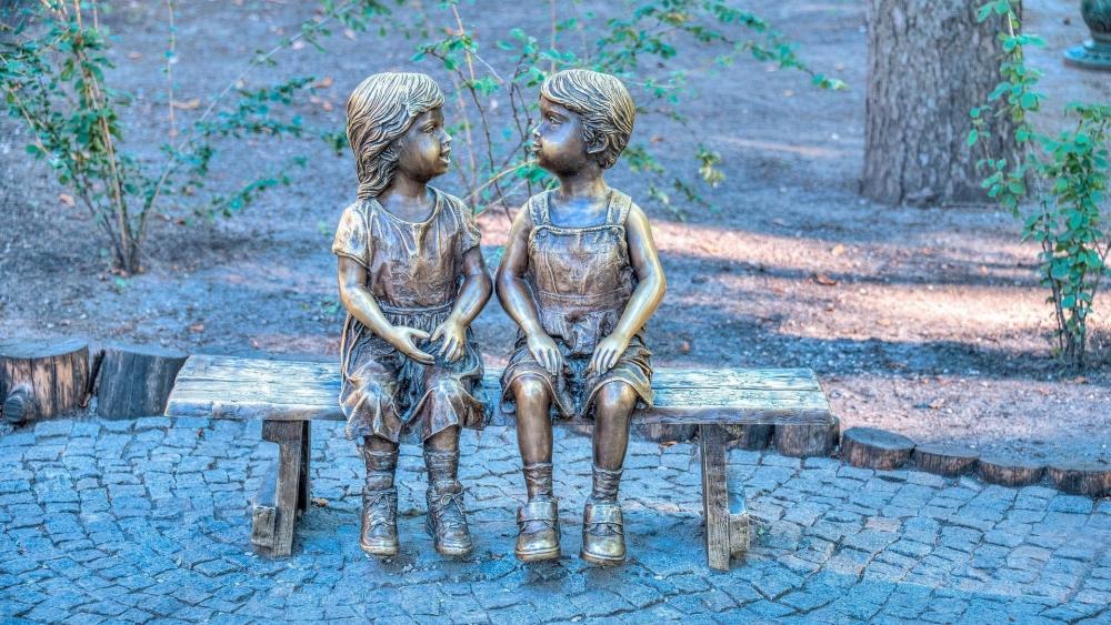 Bronze kids on bench statue wallpaper