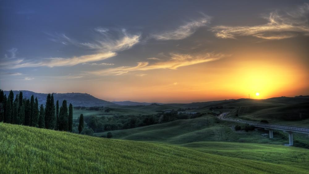 Sunset over the green landscape wallpaper