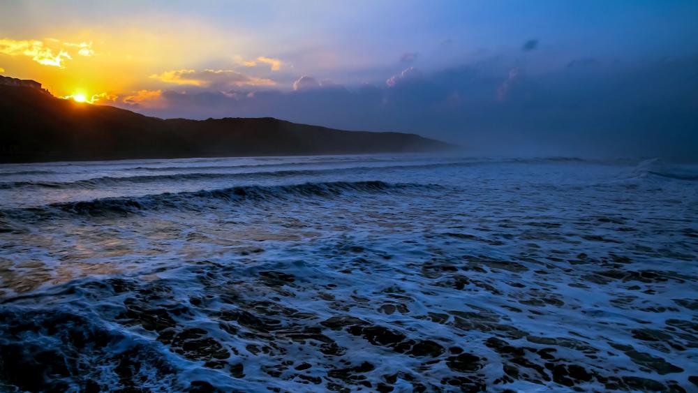 Foamy sea waves at sunset wallpaper