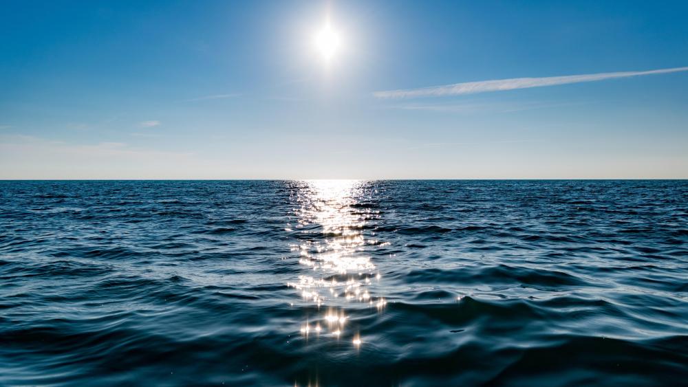 Sun on blue sky is reflected on sea wallpaper
