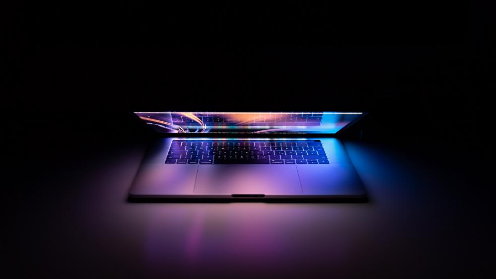 Laptop Illuminated with Dynamic Light Streams wallpaper