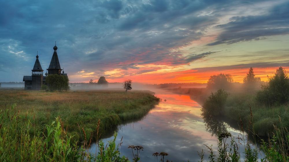 Serene Sunrise Over Misty River and Rustic Architecture wallpaper
