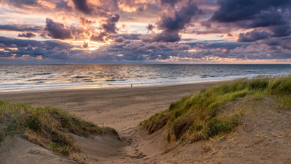 Serene Beach at Sunset with Dramatic Clouds wallpaper