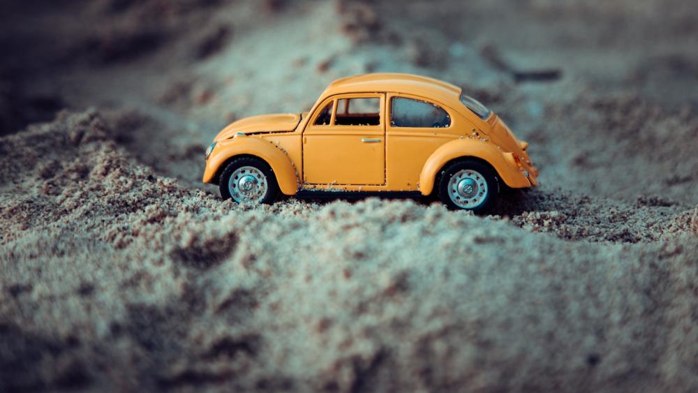 Volkswagen Beetle toy car in the sand wallpaper