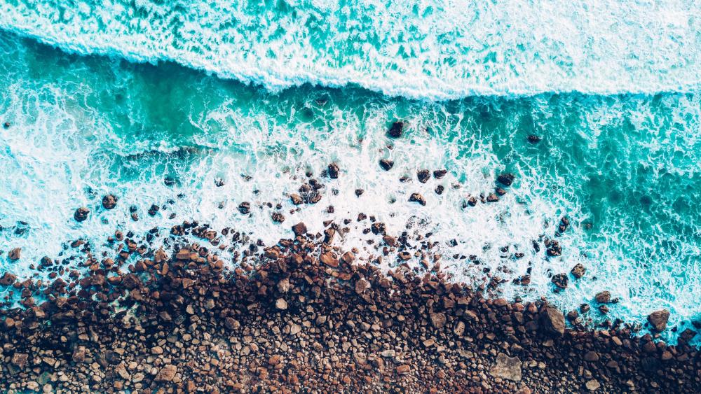Emerald Waves Caressing Pebbled Shore wallpaper