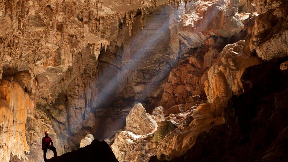 Speleologist Observing Sun Rays Inside the Terra Ronca Cave wallpaper