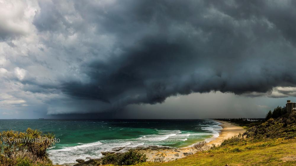 Dramatic Coastal Storm Over Emerald Waves wallpaper