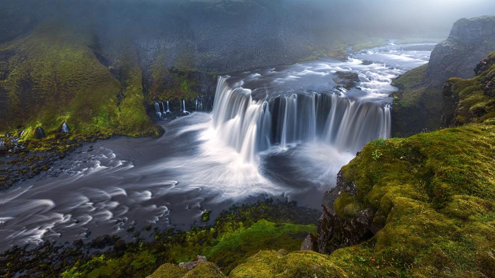 Majestic Waterfall Amidst Lush Greenery wallpaper
