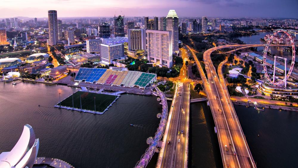 Cityscape at Dusk with Vibrant Lights and Waterways wallpaper