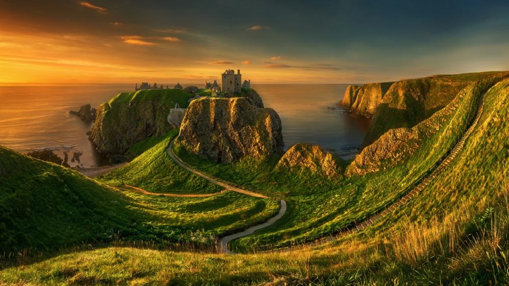 Majestic Sunset Over Rugged Coastline and Castle wallpaper