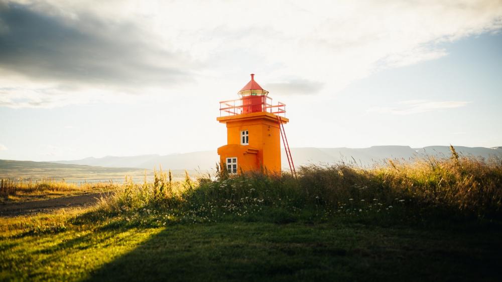 Vibrant Lighthouse Against a Serene Landscape wallpaper