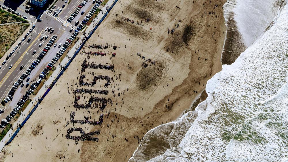 Drone View of Resist Protest on the Sand of Ocean Beach wallpaper