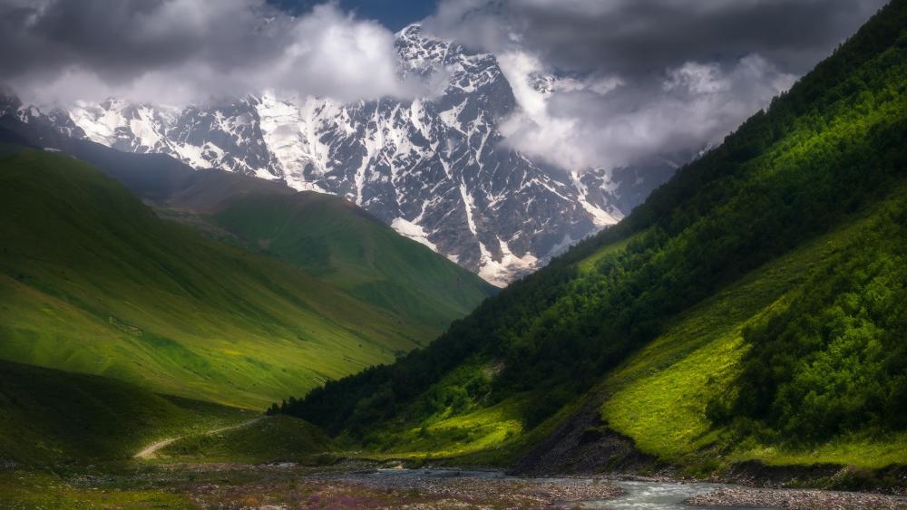 Majestic Mountain Landscape with Lush Green Valleys and Dramatic Skies wallpaper