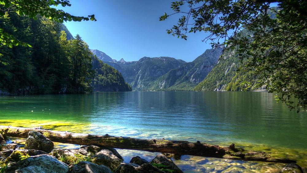 Serene Lake Surrounded by Majestic Mountains and Lush Forests wallpaper