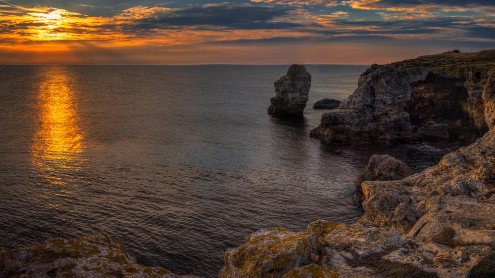 Serene Sunset Over Rocky Coastline wallpaper