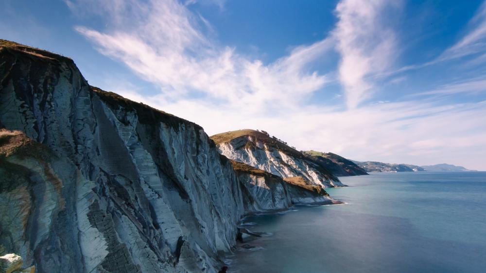 Majestic Coastal Cliffs Under a Blue Sky wallpaper
