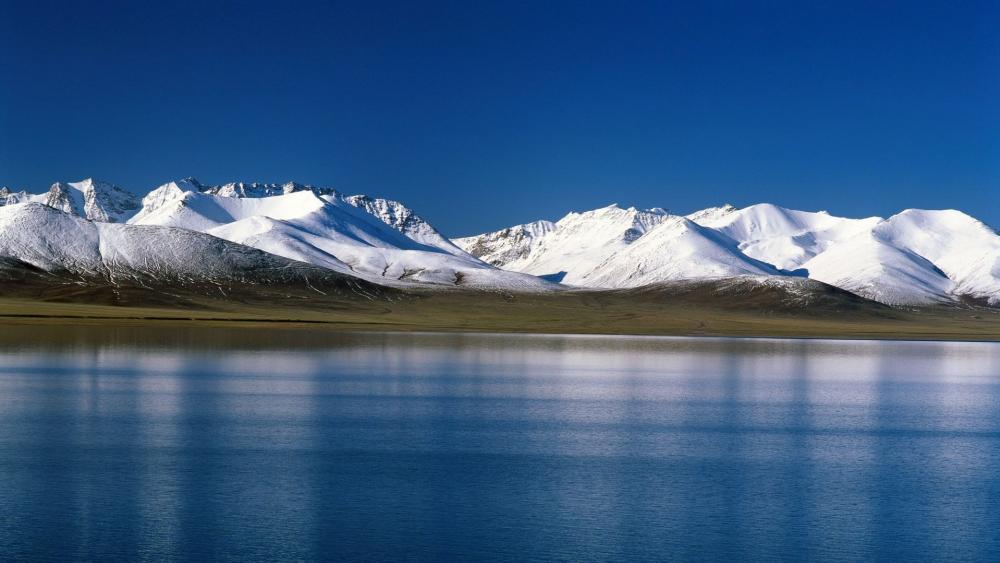 Majestic Snow-Capped Mountains by Tranquil Lake wallpaper