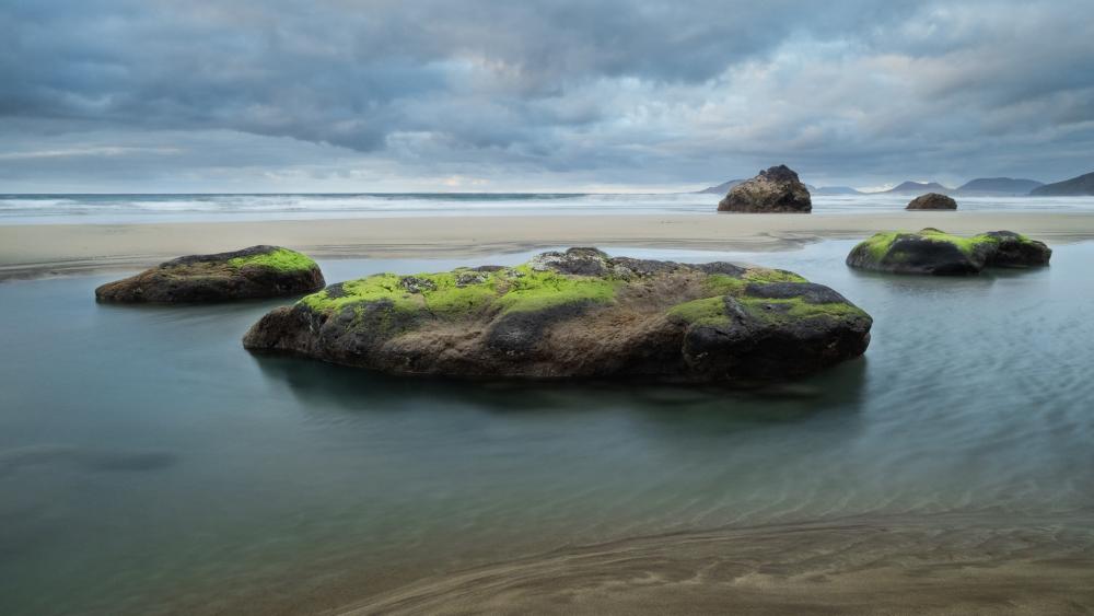 Serene Beachscape with Rocky Formations and Gentle Waves wallpaper
