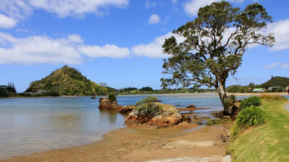 Serene Coastal Landscape Under Clear Blue Skies wallpaper