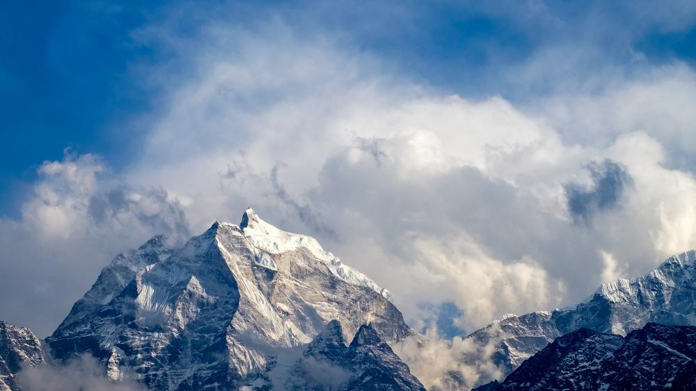 Majestic Peaks Wrapped in Clouds wallpaper