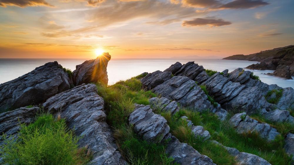 Serene Sunset Over Rocky Coastline wallpaper