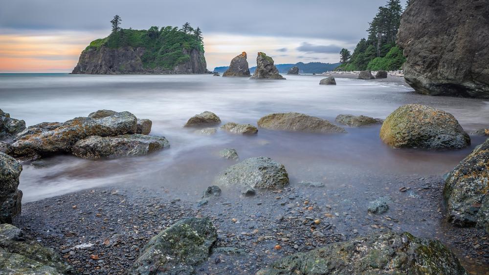 Serene Coastal Landscape with Timeless Rocks and Gentle Waves wallpaper