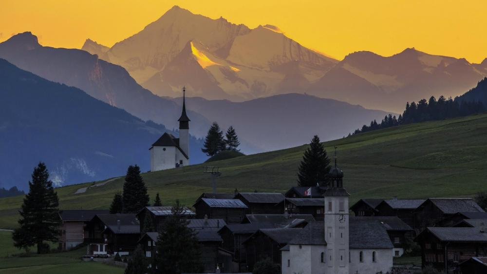 Majestic Mountain Sunrise Over Serene Village wallpaper