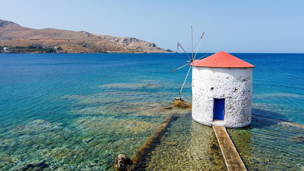 Serene Coastal Windmill by the Clear Waters wallpaper