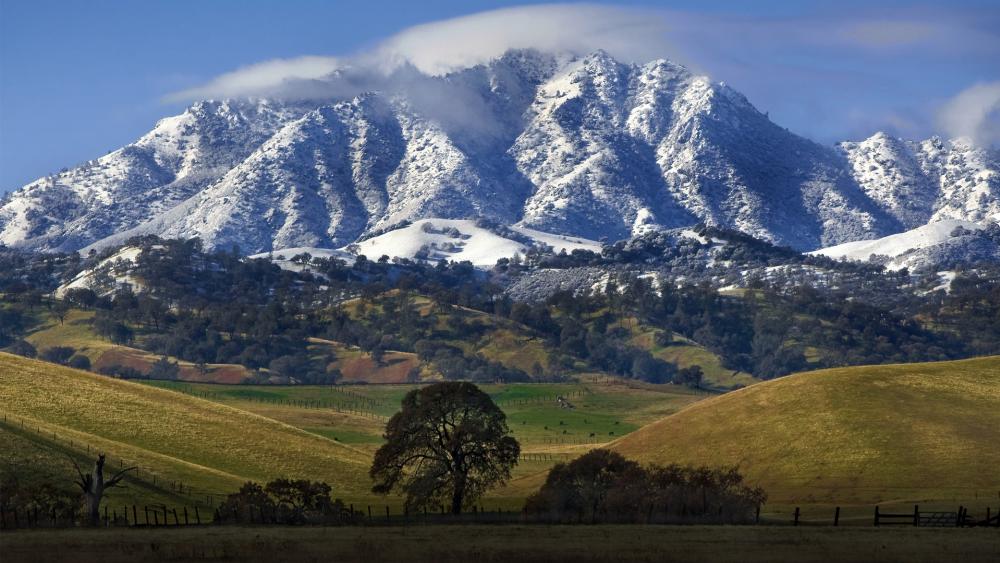 Majestic Mountains Under a Veil of Clouds wallpaper