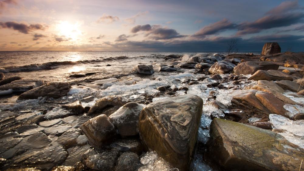 Serene Sunrise over Rocky Shoreline wallpaper