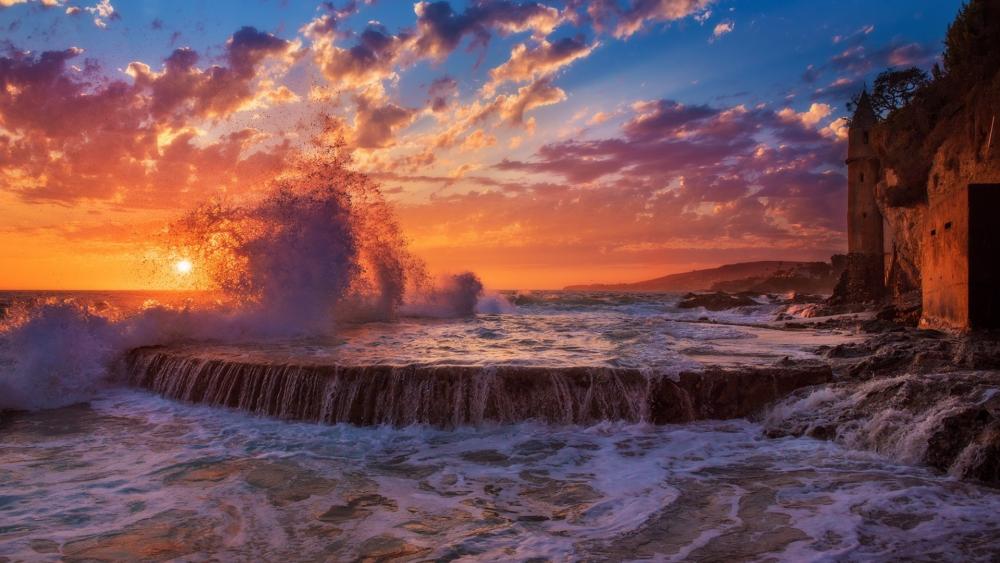 Vibrant Sunset Over Waves and Ruins wallpaper