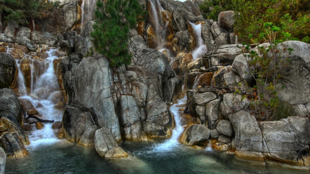 Majestic Waterfall Cascading Through Rocky Terrain wallpaper