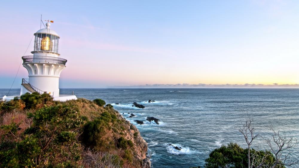 Radiant Lighthouse by the Ocean Shoreline wallpaper